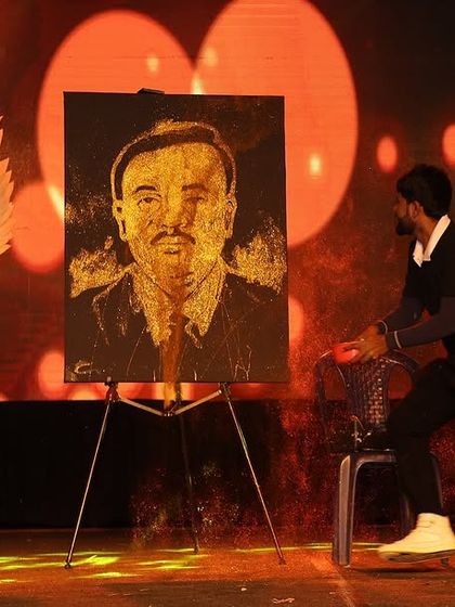 The final portrait is revealed on stage, flanked by dancers. My performances are designed to be visually spectacular, combining art with theatrical elements.