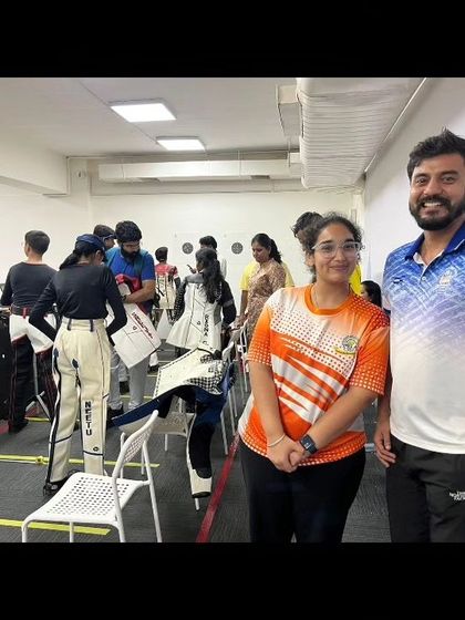A coach poses with a student during a busy competition day. We foster a supportive environment where coaches and athletes celebrate progress together.