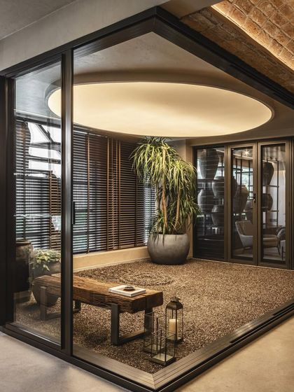 A glass-enclosed zen garden is integrated into the retail space, offering a moment of tranquility and a beautiful visual centerpiece.