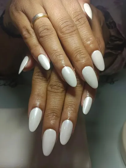 Them glazed nails. This is a simple, chic look using a pearly white polish on long, almond-shaped extensions.