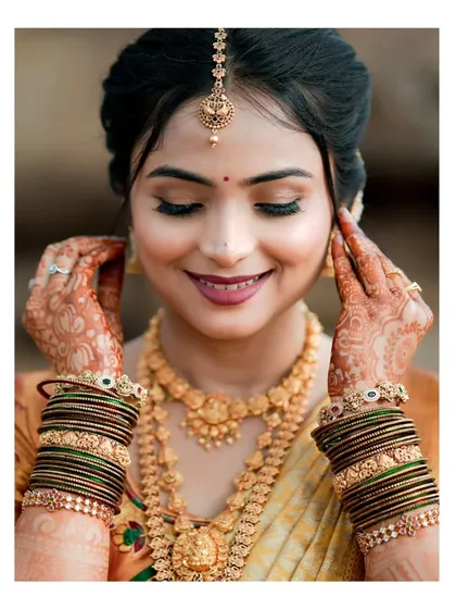 A close-up bridal portrait capturing the serene beauty of the bride on her wedding day. I focus on the intricate details of the jewelry, the flawless makeup, and the quiet happiness in her expression.