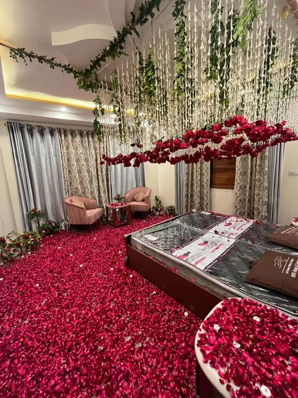 I can transform a room with more than just a bed canopy. Here, I created a floating cloud of red roses and hanging floral strings over the bed, with a dense carpet of petals on the floor for a truly immersive and luxurious feel.
