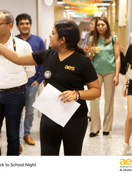 A student ambassador guides parents through the hallways during Middle School Back to School Night. This event is a crucial partnership between home and school, giving parents insight into their child's learning journey.