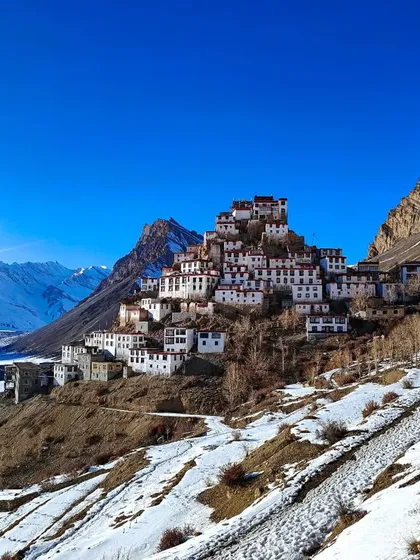 The iconic Kee Monastery in Spiti Valley, perched under a brilliant blue sky. This shot captures the scale and spiritual serenity of the Himalayas, a perspective only possible with high-altitude landscape photography.