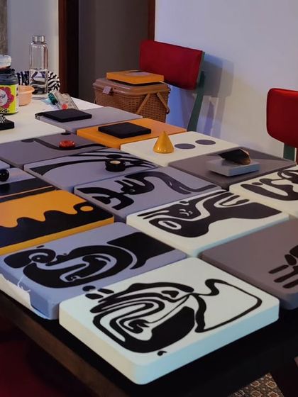 The collection of hand-painted panels for the Hyderabad project laid out on a table in the studio before installation.