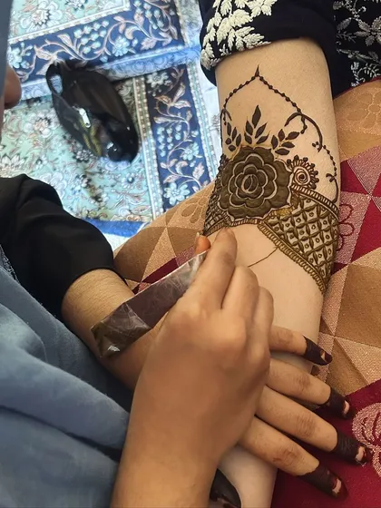 Let the mehendi session begin. This shot captures the start of a beautiful design, with the first few lines being carefully applied.