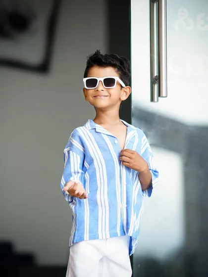 A stylish shot of a five-year-old boy posing with a cool expression for his birthday photoshoot.