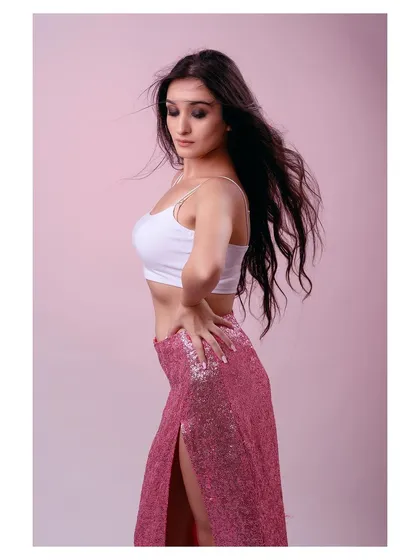 A side profile of the same look, highlighting the texture of the sequined skirt and the model's pose.