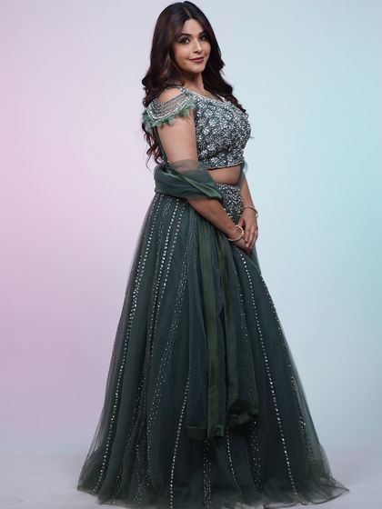A full-length view of the dark green lehenga, showing how the A-line skirt and embellished top create a classic and elegant silhouette.