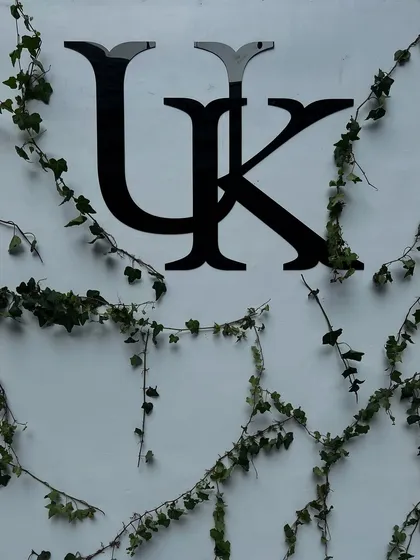 The custom 'UK' monogram for the couple, elegantly displayed on a white wall with climbing ivy for a natural, organic feel.
