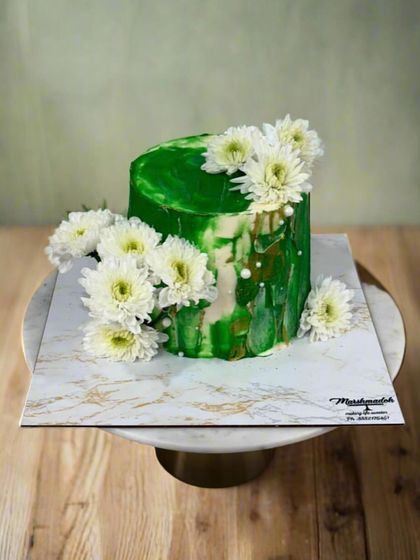 Another view of the demure green and white cake, showing the texture and the beautiful arrangement of fresh flowers.