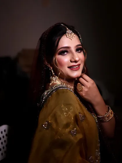 Adding the finishing touches for your big day. This candid shot captures a moment of focus and precision during the makeup application.