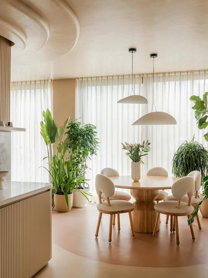Another view of the dining space, showing its connection to the open kitchen. The consistent use of natural materials and a neutral palette ensures a harmonious flow throughout the home.