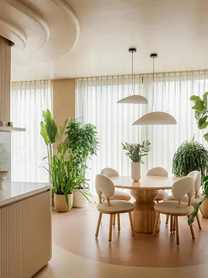 Another view of the dining space, showing its connection to the open kitchen. The consistent use of natural materials and a neutral palette ensures a harmonious flow throughout the home.