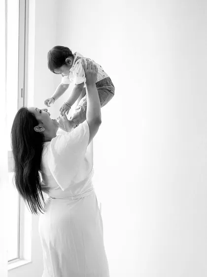 Honest and joyful. This black and white photo of a mother lifting her child high in the air is full of pure emotion and happiness, a perfect memory of their bond.