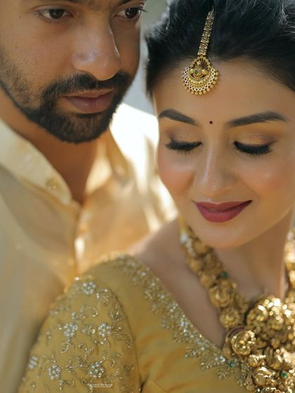 An intimate close-up showing the bride's flawless makeup. The soft gold eyeshadow and defined liner make her eyes pop, while her skin looks absolutely radiant.