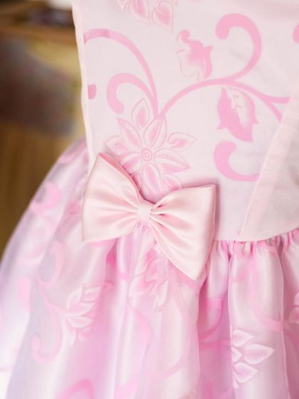 A promotional image for my sale, featuring a close-up of a pink organza dress. The detail in the fabric and the perfect bow are what make my dresses special.