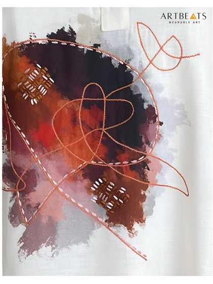 A close-up on the heart of the Reverie in Red dress. Here you can see the hand-drawn abstract art, with its layered colors and delicate threadwork embroidery, bringing the fabric to life.