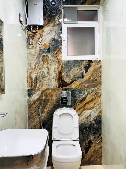 The accent wall in the bathroom, featuring a bold, earthy-toned marble tile that adds a touch of natural drama to the space.