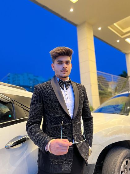 A client looking regal in a black tuxedo with intricate beadwork. The detailed craftsmanship makes this a standout piece for any formal occasion.