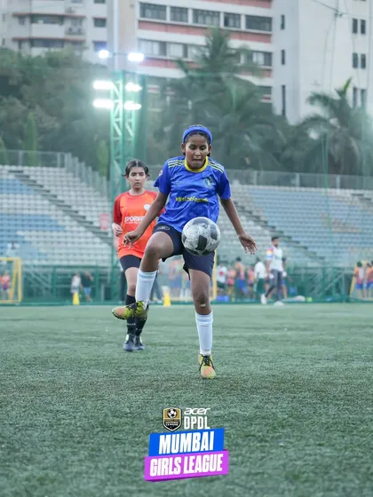 A player skillfully juggles the ball to maintain control during a match. This demonstrates the high level of technical ability our girls develop through dedicated training.