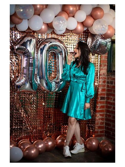 A fun and celebratory shot from a 10-year industry anniversary photoshoot, complete with balloons and a festive backdrop.