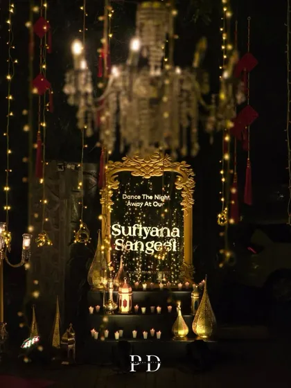 A beautiful welcome sign for a 'Sufiyana Sangeet'. The ornate gold mirror, surrounded by candles and lanterns, invites guests to 'Dance The Night Away' in style.