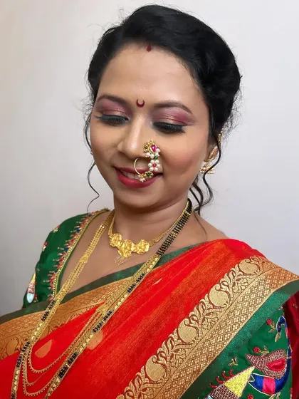 A close-up of the bride's happy face. The makeup is soft and pretty, with a shimmery pink eyeshadow and a matching lip color.