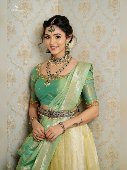 A full-length view of the traditional lehenga against a patterned wallpaper, showing the versatility of the look for different studio backdrops.