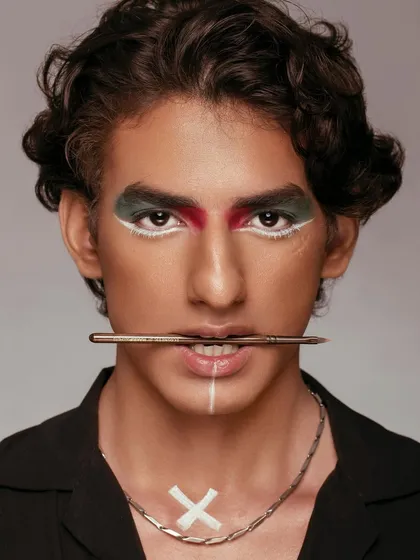 We believe beauty is for everyone. This editorial shot showcases bold, graphic makeup on a male model, challenging conventions and highlighting the versatility of our artistic approach. The focus is on sharp lines and a powerful, direct gaze.