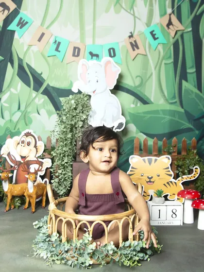A 'Wild One' first birthday setup with a banner and cute animal cutouts, perfect for a jungle adventure theme.