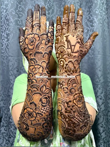 This design features the initial 'A' on one palm, surrounded by dense and beautiful patterns.