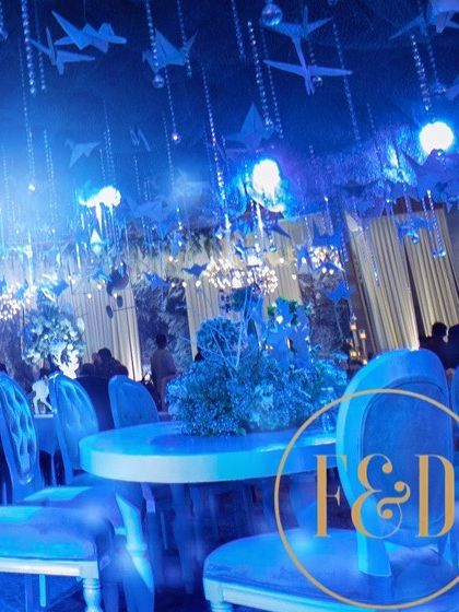 The dining tables set under the enchanting blue canopy. The decor creates a cohesive and immersive experience for guests throughout the evening.