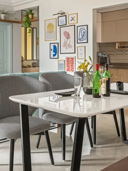 The dining area of the Zen Residence is open and connected to the living space. A gallery wall of colorful, abstract art provides a vibrant backdrop, reflecting the home's contemporary and artistic design ethos.