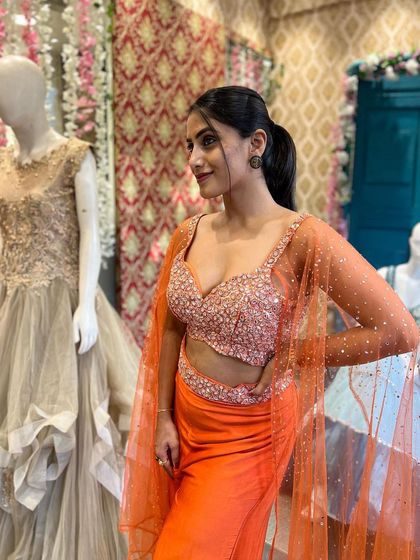 The sparkle on this orange crop top is just stunning. Paired with comfortable pants and a cape, this rental outfit is perfect for dancing the night away at a sangeet.