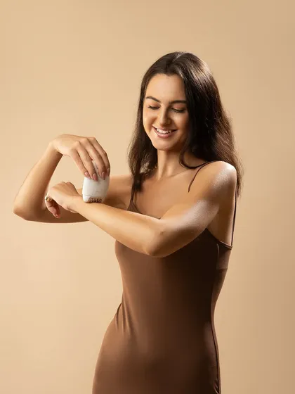 Capturing the moment of application for a personal epilator. The model's relaxed expression and the soft, neutral background create a sense of comfort and ease, making the product seem approachable and user-friendly.
