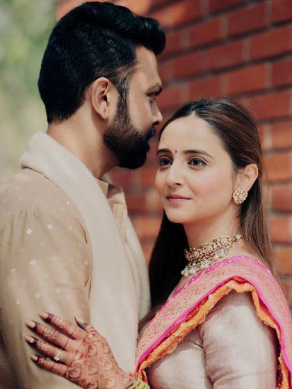 A perfect pair, captured in a moment of quiet intimacy. The bride's gaze towards the camera is captivating, while the groom looks at her with adoration. This portrait is subtle yet incredibly powerful.