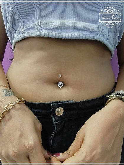 A fresh belly piercing with a heart-shaped stud. We have a wide variety of jewelry to choose from to make your new piercing truly special.