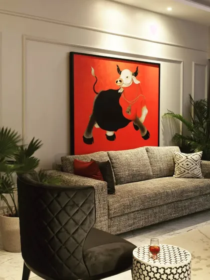 This living room was designed around the client's "red show stopper" bull painting. I used a monochrome palette of greys, blacks, and whites to make the art pop, proving that a home's design can be built from a single piece you love.