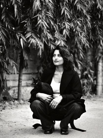 A woman holding a black cat, their forms blending together in this beautiful black and white portrait. It’s a moment of quiet companionship.