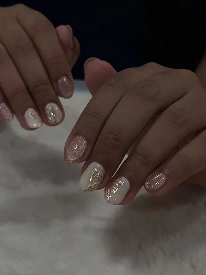 A perfect summer look. These nails feature a soft glitter base with delicate gold butterfly accents, a simple yet elegant design.