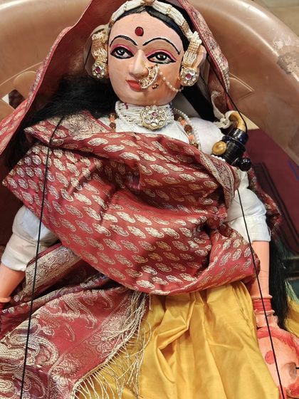 A detailed look at one of our traditional string puppets. The elaborate headgear, nose ring, and rich fabrics are all handcrafted to bring the character to life, reflecting the rich aesthetic traditions of our land.