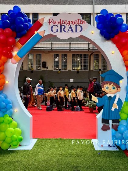 The grand entrance arch for the kindergarten graduation ceremony. We used a rainbow of balloons and fun school-themed props to create an exciting welcome for the students and their families.