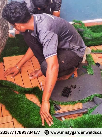 Our team custom cutting and fitting artificial grass around WPC tiles for a seamless and professional finish on a balcony floor.