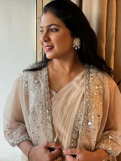A modern yet traditional party look. The client is wearing a beautiful saree with a mirror-work jacket.