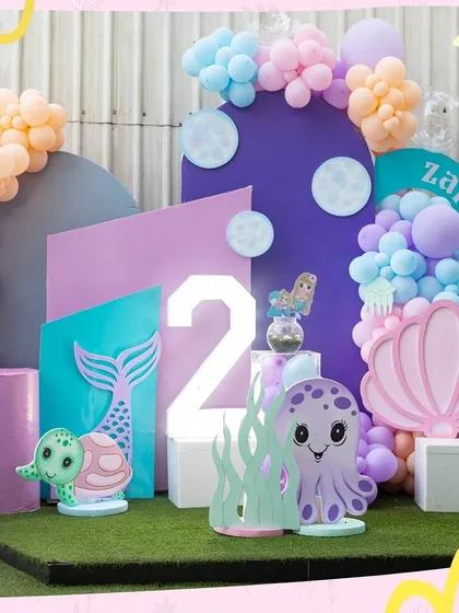An enchanting under-the-sea theme for a second birthday. The pastel color palette, mermaid tails, and cute sea creatures like the octopus and turtle make for a magical photo backdrop.
