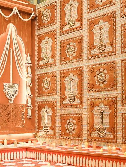 A view of the mandap wall, featuring jharokhas with mogra jaali work and panels of hand-pasted flowers.