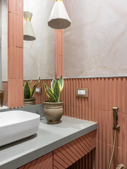 Another view of the bathroom with fluted terracotta tiles. This shot highlights the snake plant, which adds a touch of green and a sculptural element to the space.