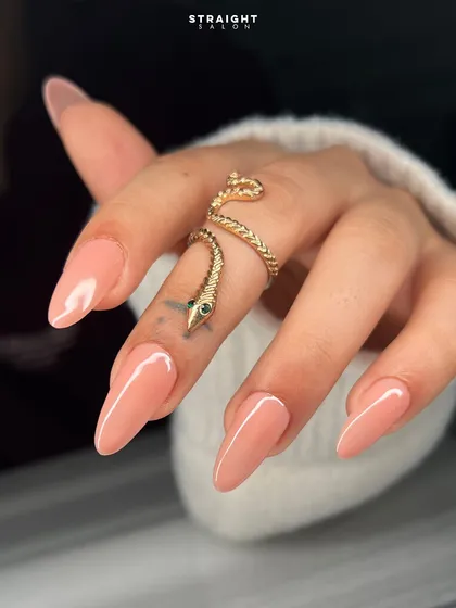 A close-up on the beautiful almond shape and the flawless application of this soft nude polish. It's a look of pure, simple elegance.