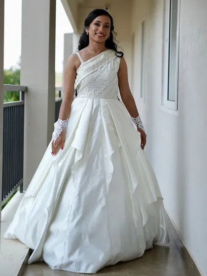 For my clients looking for something different, I also design and rent Western-style gowns. This beautiful bride is wearing a custom one-shoulder Christian wedding gown with a layered skirt.